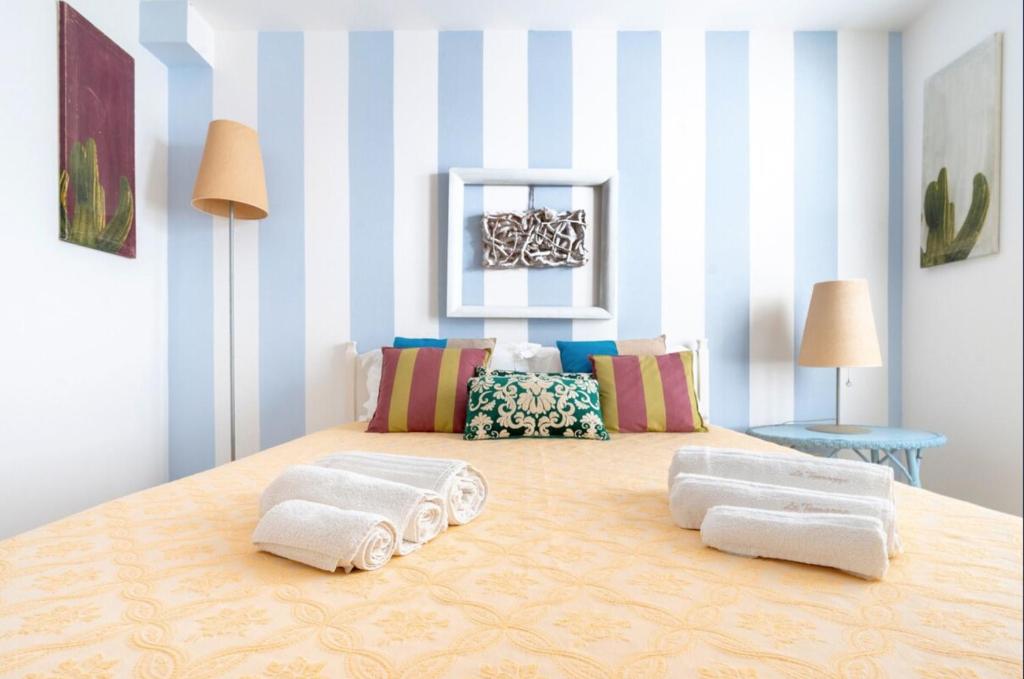 a room with blue and white striped walls and two pillows at Le Terrazze in Otranto