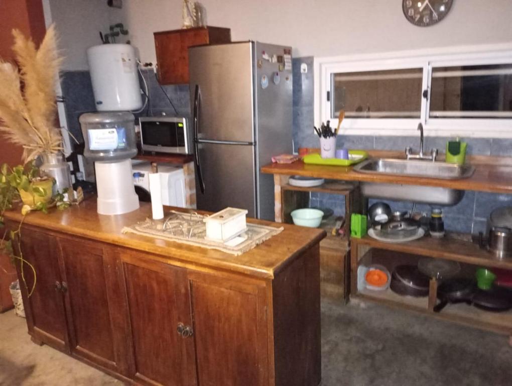 a kitchen with a counter with a refrigerator and a sink at Casa Quinta San Miguel del Monte in San Miguel del Monte