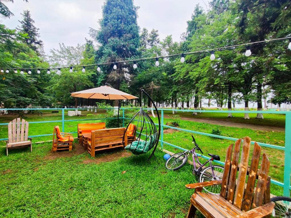 a park with chairs and an umbrella and a swing at Park & Beach House in Ureki Magnetiti, Sleeps 6 in Ureki