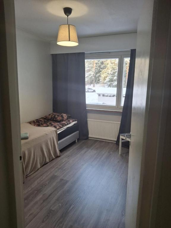 a small bedroom with a bed and a window at LibO-apartment, Myllymäki 19 X in Lahti