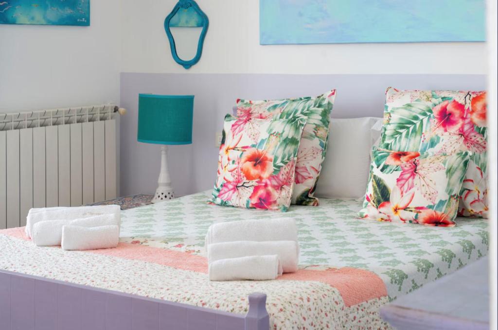 a bed with pillows on it with a green and pink at Le Terrazze in Otranto