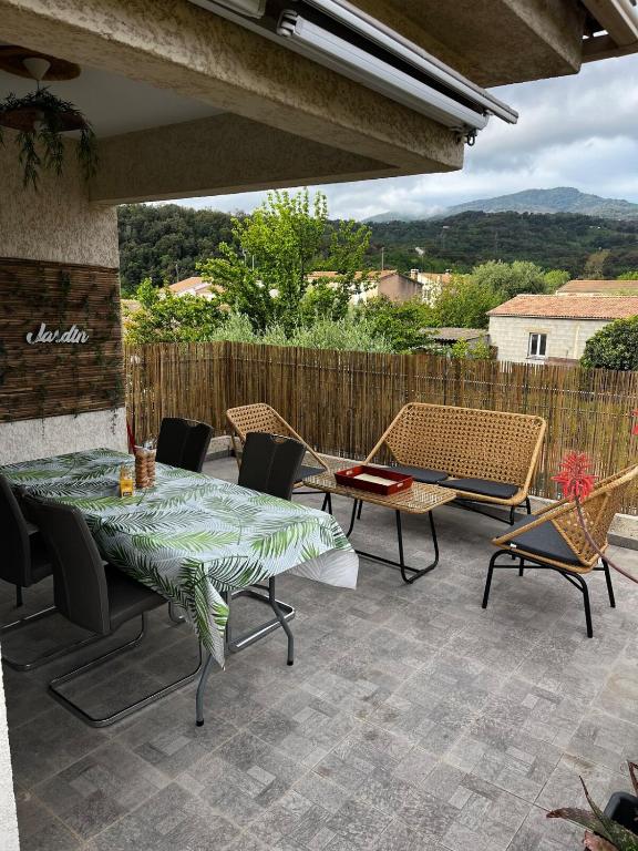 un patio avec une table et des chaises et une vue dans l'établissement Appart, résidentiel penta-di-Casinca, à Penta-di-Casinca