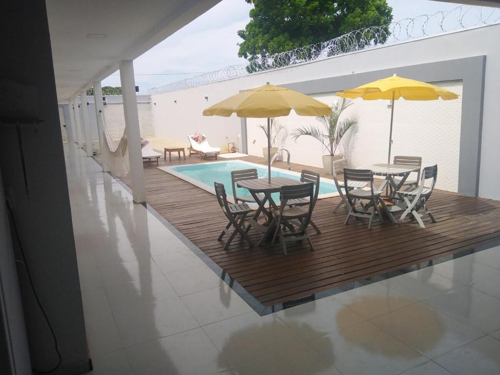 a wooden deck with chairs and a table and umbrella at casa in Prado