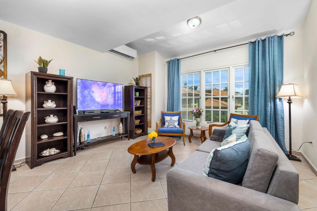 uma sala de estar com um sofá e uma TV em Palma Real 29 em Palm Beach