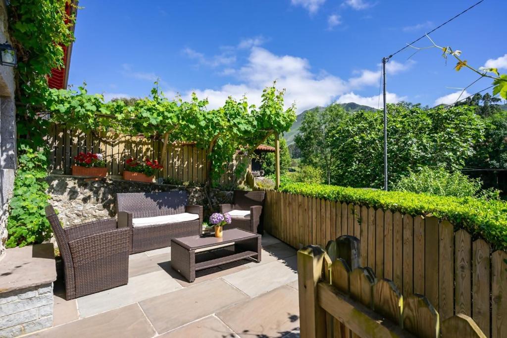 eine Terrasse mit Stühlen, einem Tisch und einem Zaun in der Unterkunft La Corvera en Collera, Ribadesella in Collera