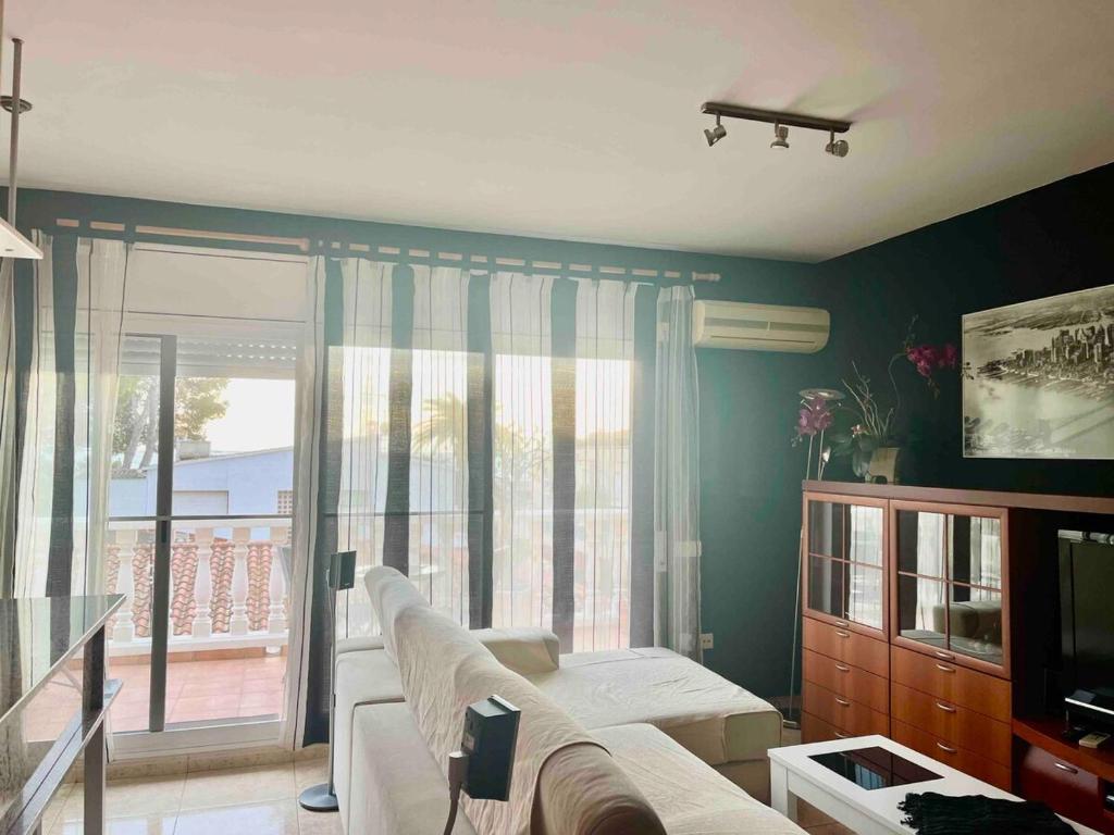 a living room with a couch and a large window at Suis in Sant Carles de la Ràpita
