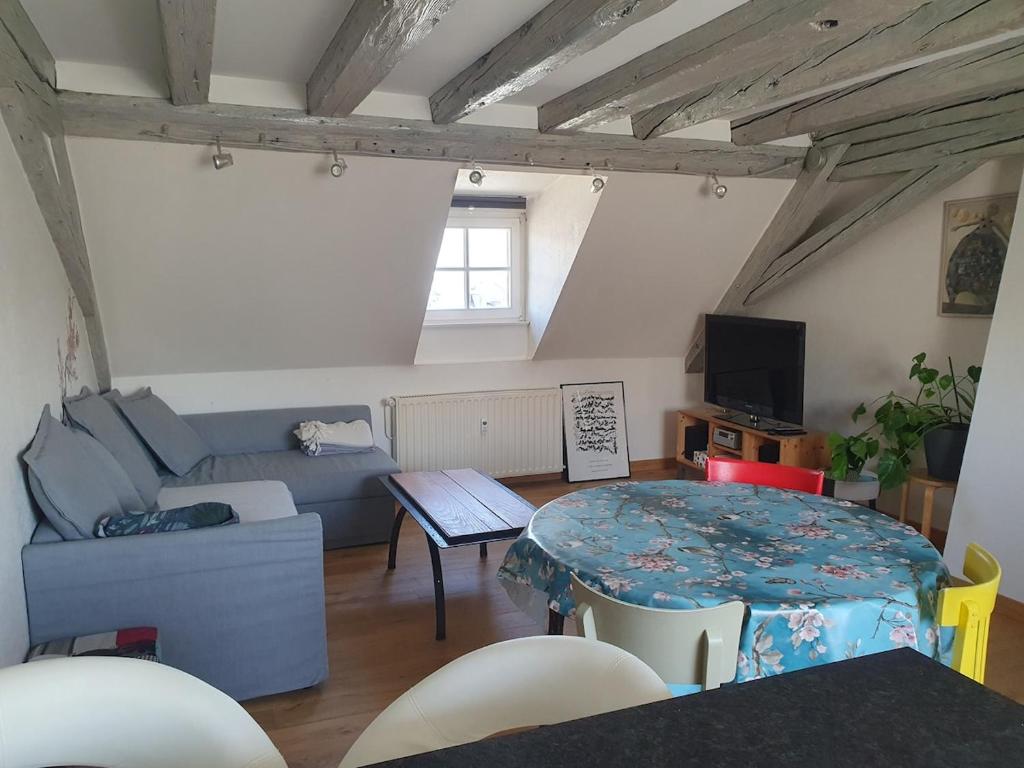 un salon avec un canapé bleu et une table dans l'établissement Mon Ptit Nid T3 Duplex au coeur de la Krutenau, à Strasbourg