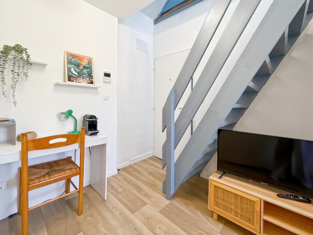 - un salon avec une télévision et un escalier dans l'établissement Topaze - Centre Historique - Proche Gare - Calme, à Rennes