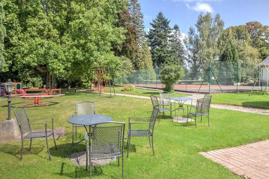 a group of chairs and tables in a park at Parc Hôtel in Wangenbourg