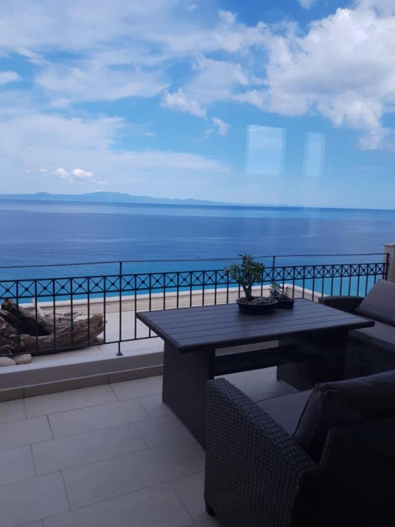 a balcony with a table and a view of the ocean at On the rock afytos in Afitos