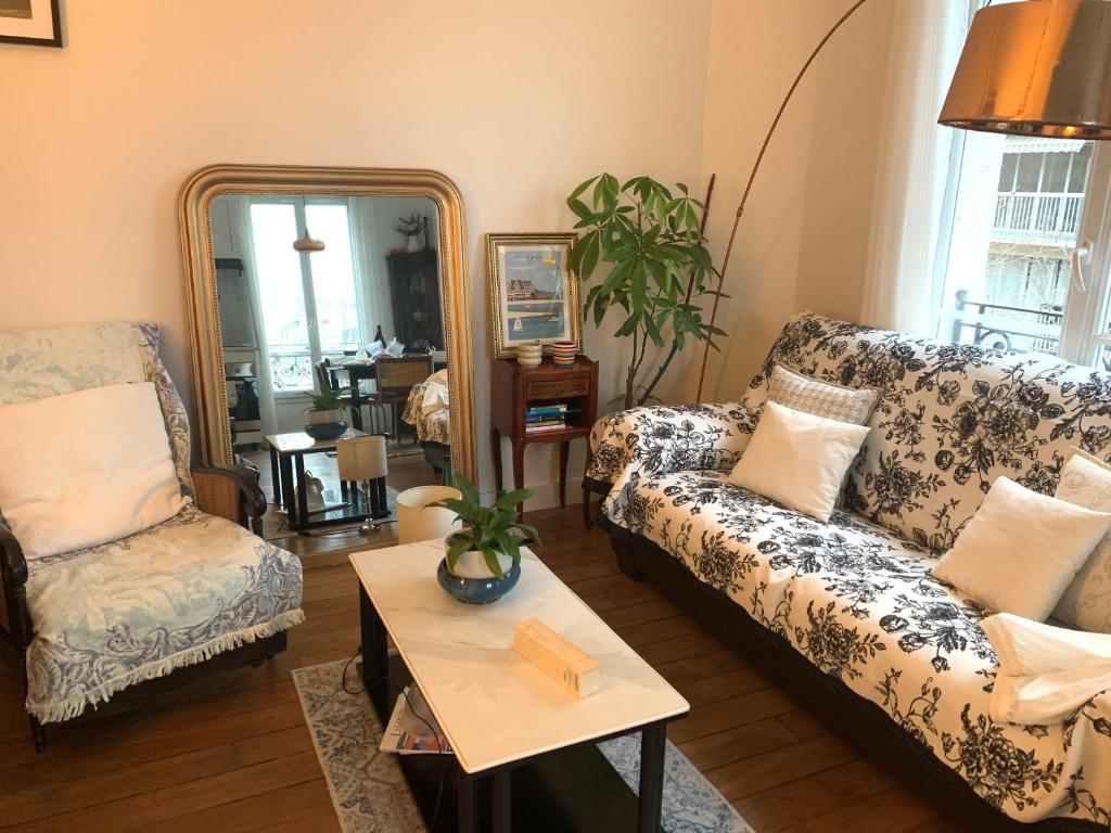 un salon avec deux canapés et une table dans l'établissement Cozy Frenchy apartment nearby La Seine, à Paris