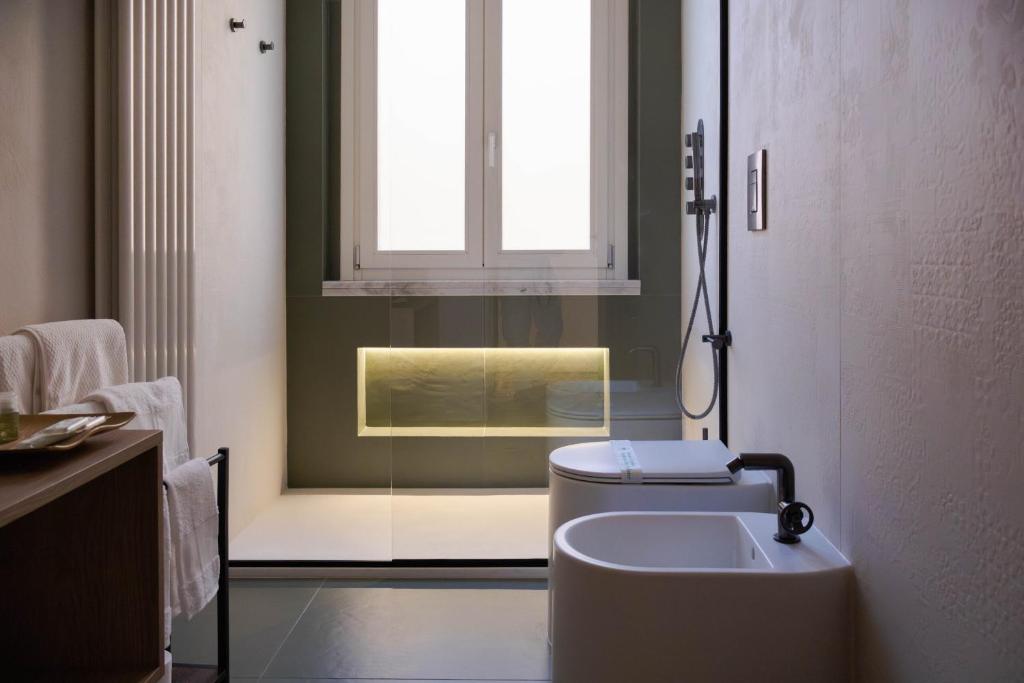 ein Bad mit einem WC, einem Fenster und einem Waschbecken in der Unterkunft La Dimora del Postino Matera - Casa Vacanze in Matera