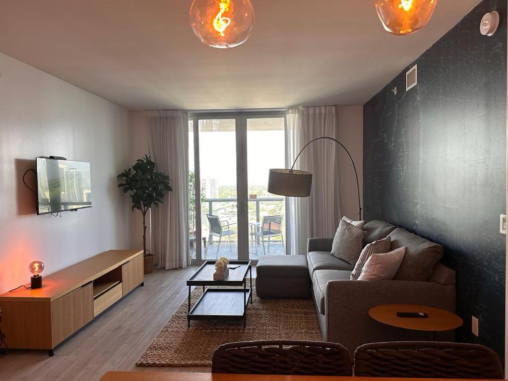 ハランデール・ビーチにあるCozy 1BR Retreat wPool BeachService & Full Kitchenのソファとテーブルのあるリビングルーム