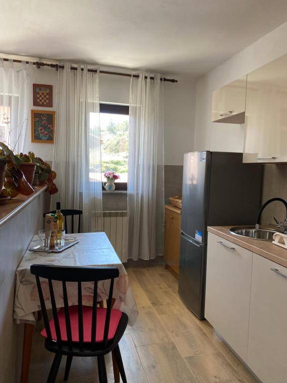 a small kitchen with a table and a refrigerator at Apartman Mira in Opatija