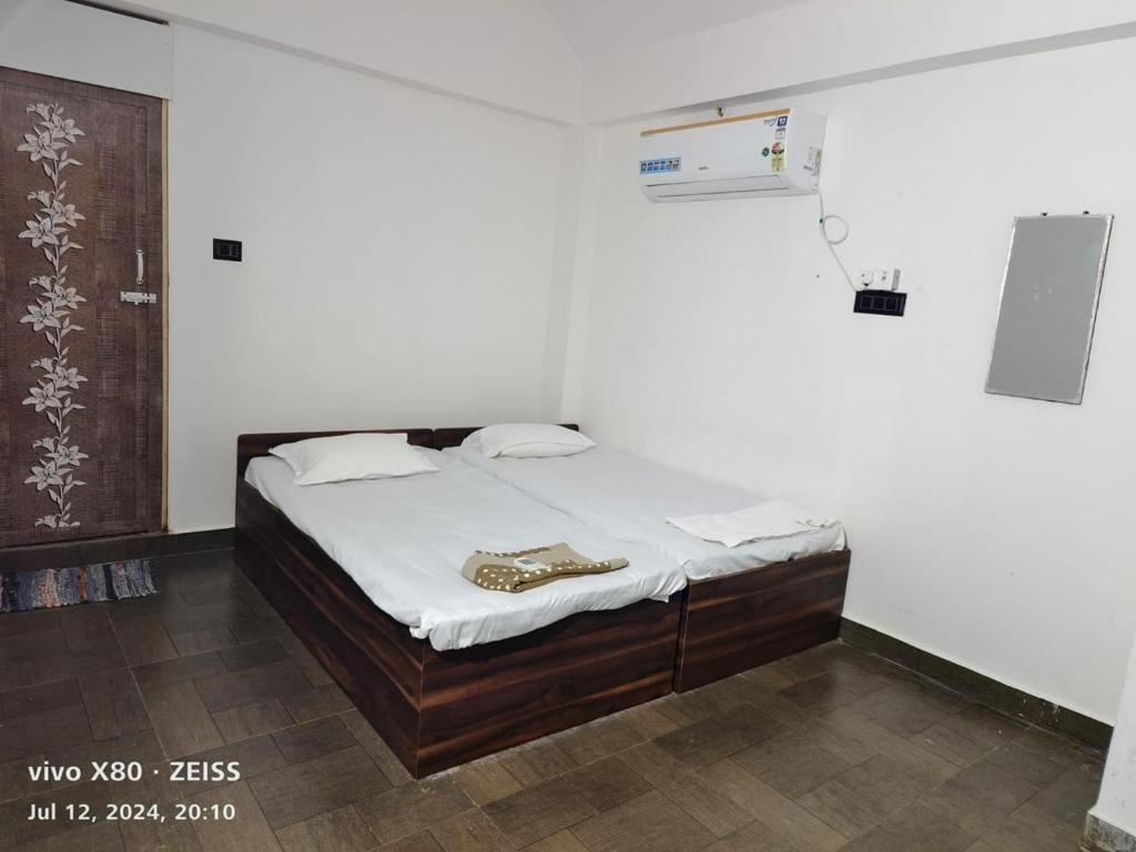 Un dormitorio con una cama en una habitación blanca. en Sai villa, en Tiruvannāmalai