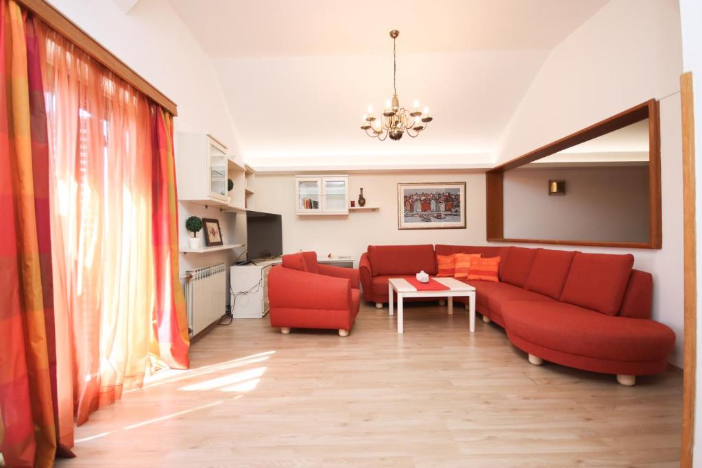 ein Wohnzimmer mit zwei roten Sofas und einem Tisch in der Unterkunft Apartment Macan in Cavtat