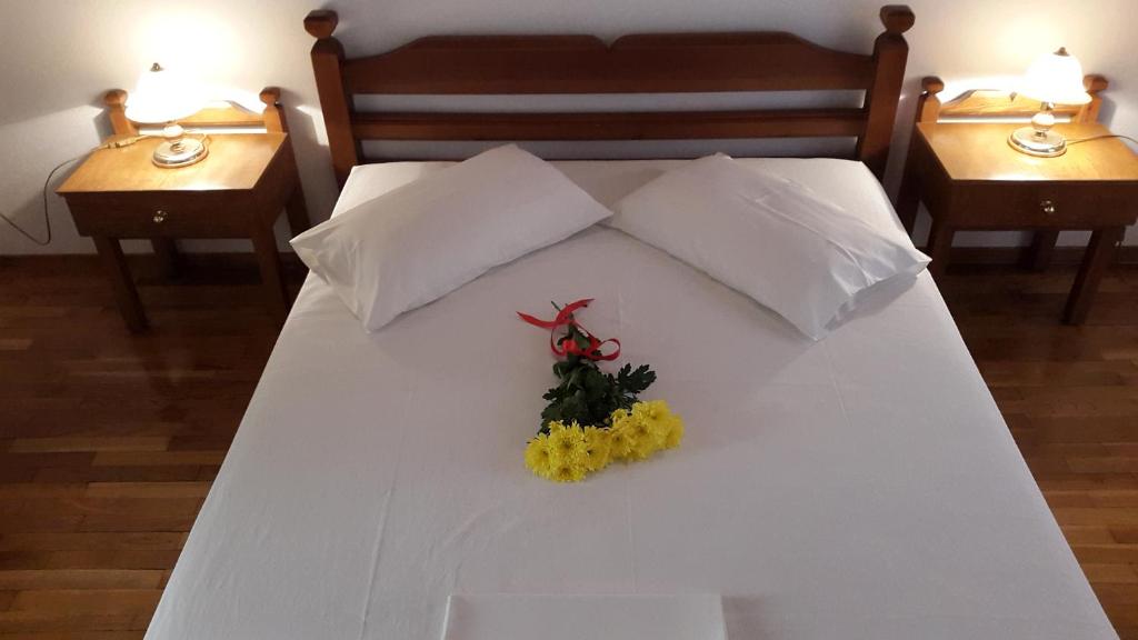 a white bed with a flower arrangement on it at Epic Rooms in Delphi
