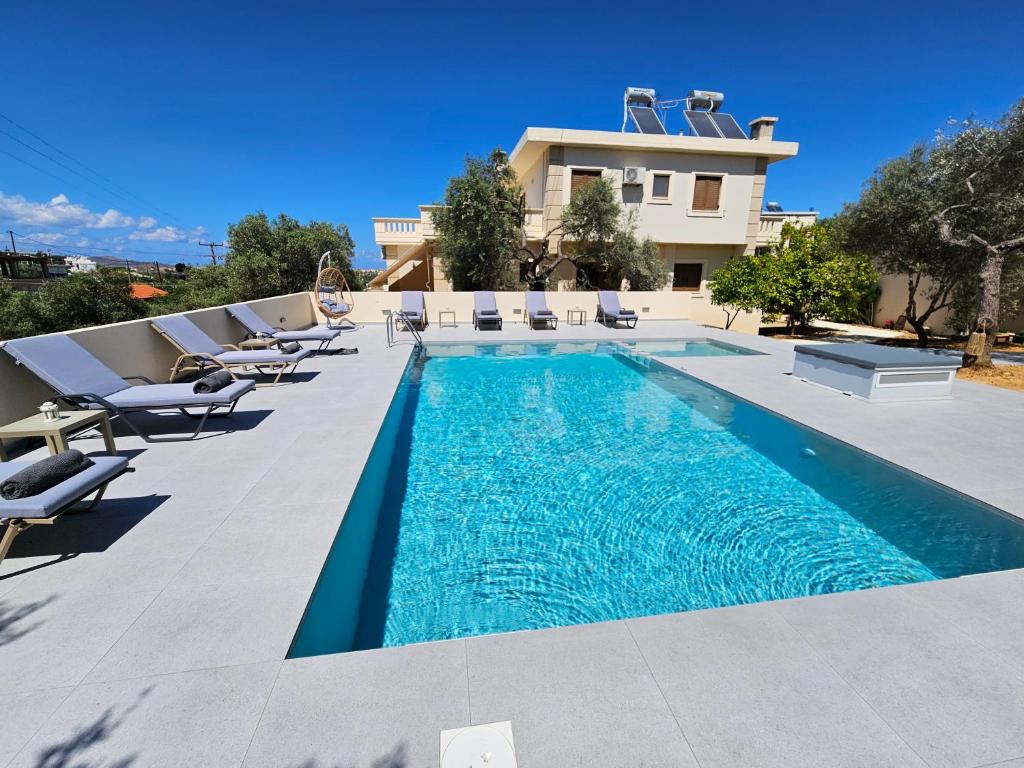 a swimming pool with lounge chairs and a house at Villa Daratso with private pool view to the sea in Daratso