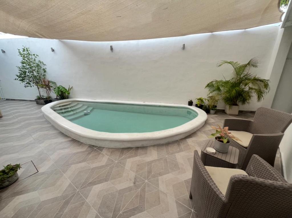 a large bath tub in a room with chairs and plants at El Rinconcito in Valladolid
