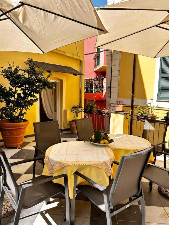 a patio with a table and chairs and umbrellas at La Poesia Apartment in Monterosso al Mare