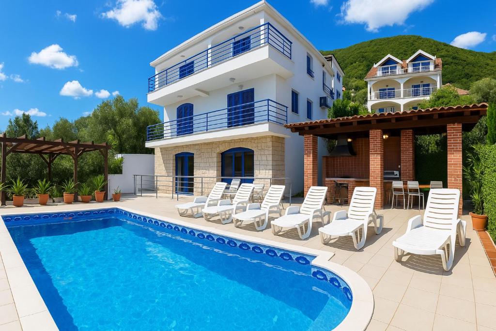 a villa with a swimming pool and a house at Villa Sea-N-Sun, 7 bedrooms & Pool, nearby Portonovi Marina. in Ðenovići