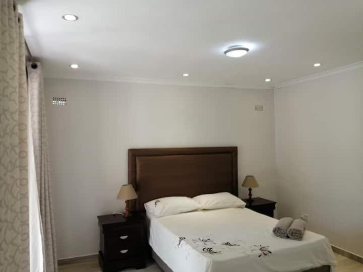 En eller flere senge i et værelse på Musasa gardens