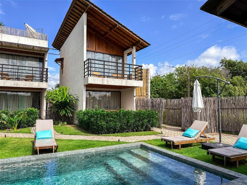 a house with a swimming pool next to a house at Alameda Lounge Pousada in Pôrto de Pedras