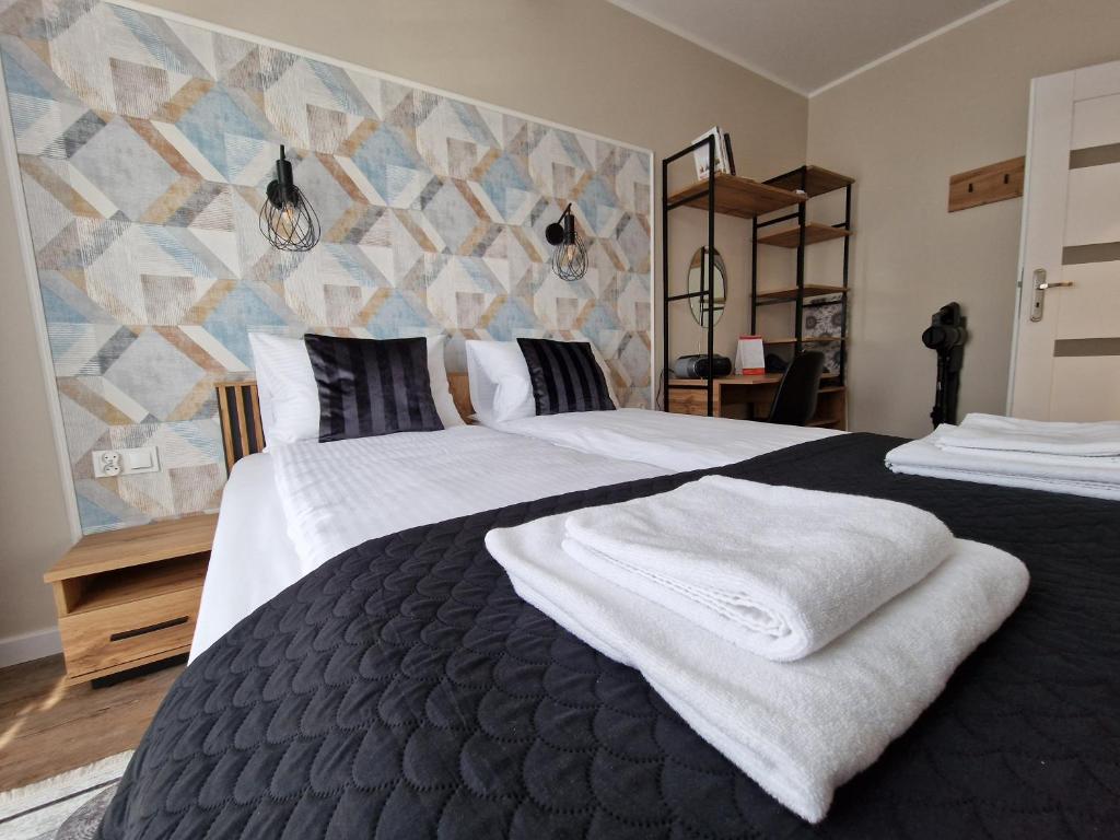 Un dormitorio con dos camas con toallas encima. en Apartament Busko Odnova, en Busko-Zdrój