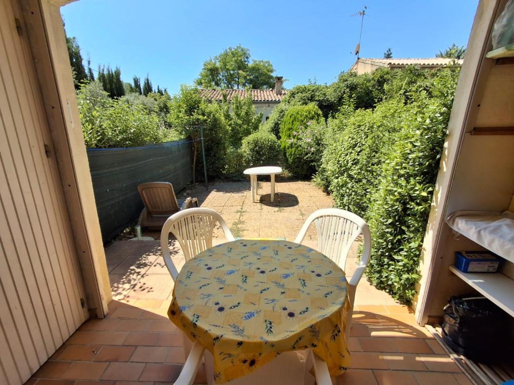 une table et deux chaises sur une terrasse dans l'établissement Studio avec Jardin, à Gréoux-les-Bains