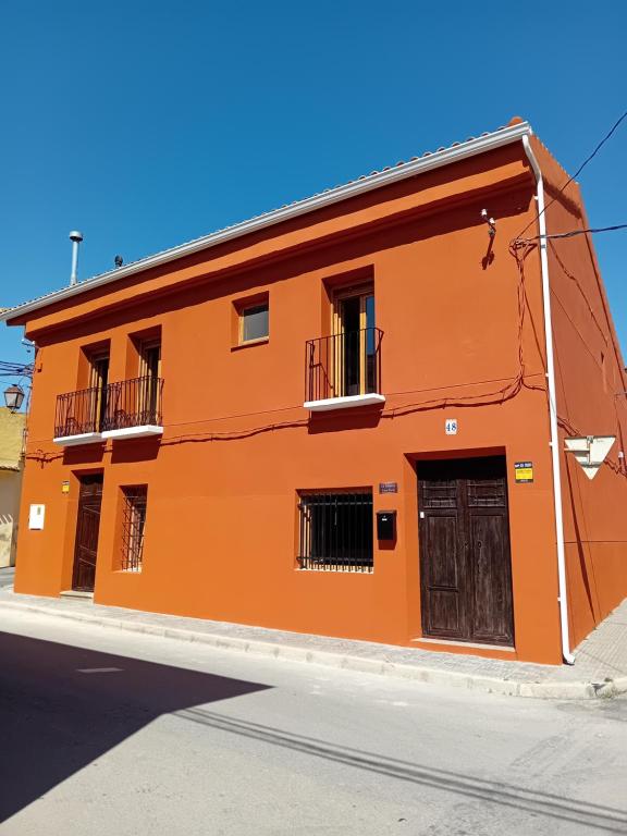 an orange building on the side of a street at Casa Rural La Palmera in Cañada del Trigo
