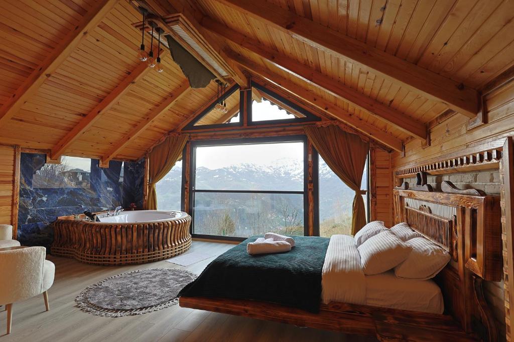 a bedroom with a tub and a bed in a cabin at Avida Bungalov in Çamlıhemşin