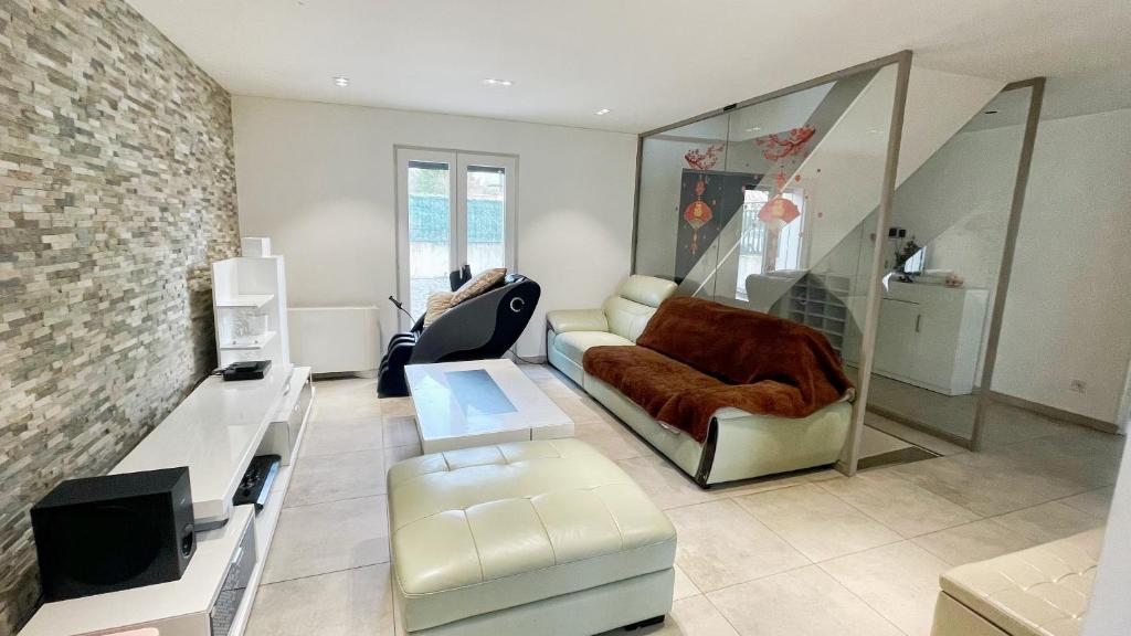 una sala de estar con un sofá y una silla en Maison Antony, en Antony