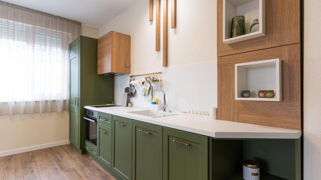 a kitchen with green cabinets and a sink at LIMIDI HOMES - Spacious 2-Bedroom City Centre in Veliko Tŭrnovo