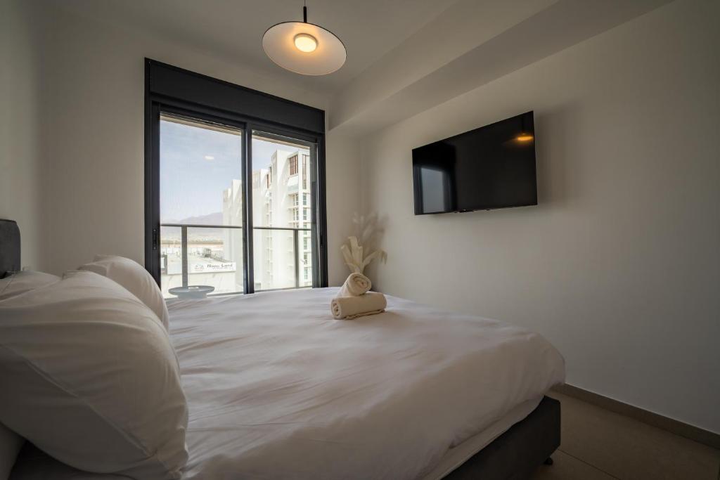 ein Schlafzimmer mit einem großen Bett mit einem Teddybär darauf in der Unterkunft Valencia Apartment - By Harim in Eilat