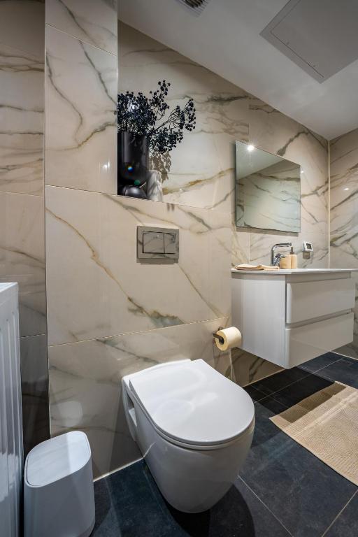 ein Badezimmer mit einer weißen Toilette und einem Waschbecken in der Unterkunft Valencia Apartment - By Harim in Eilat