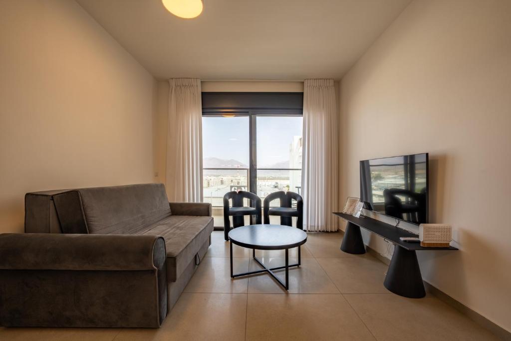 埃拉特Valencia Apartment - By Harim的带沙发、桌子和椅子的客厅