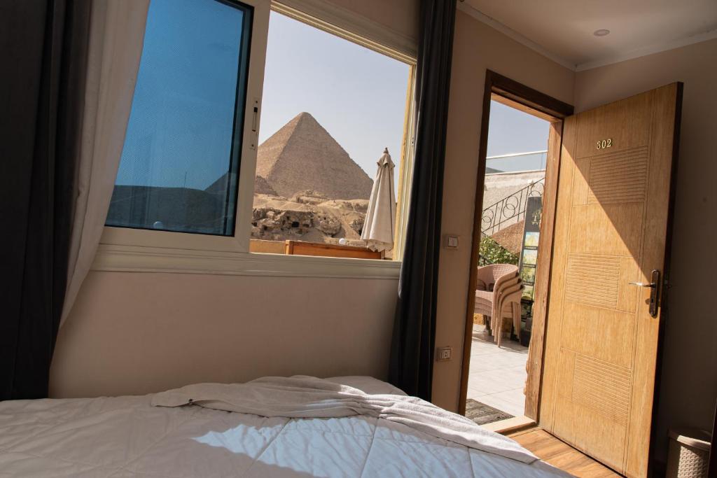 Een bed of bedden in een kamer bij Tamara Pyramids View