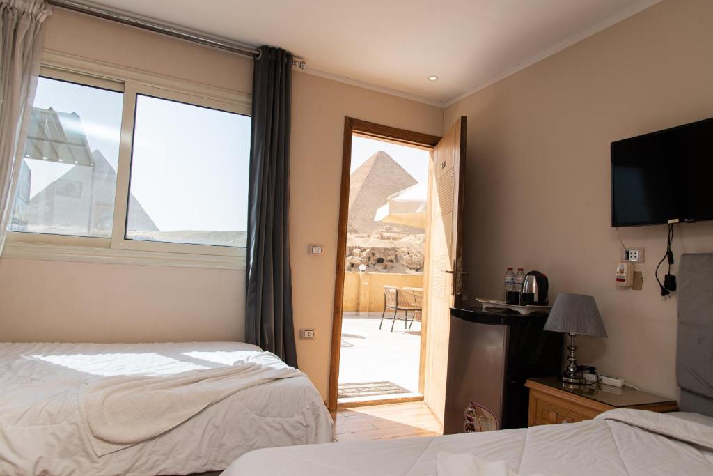 een hotelkamer met uitzicht op de piramides bij Tamara Pyramids View in Caïro