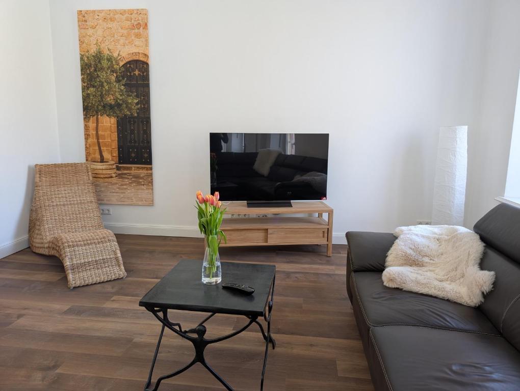 Winzervilla Kammerhof - 3x stilvolle & geräumige FeWos mit Moselblick, 2-12 Gäste buchbar, direkt am Moselradweg في برونبيبيرغ: غرفة معيشة مع أريكة وطاولة