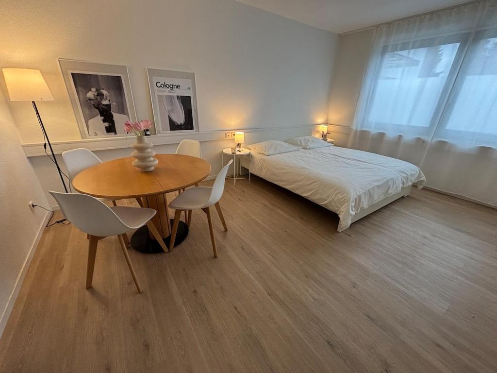 Un dormitorio con una cama y una mesa y sillas. en Great Location Airport Exhibition Center Downtown, en Düsseldorf