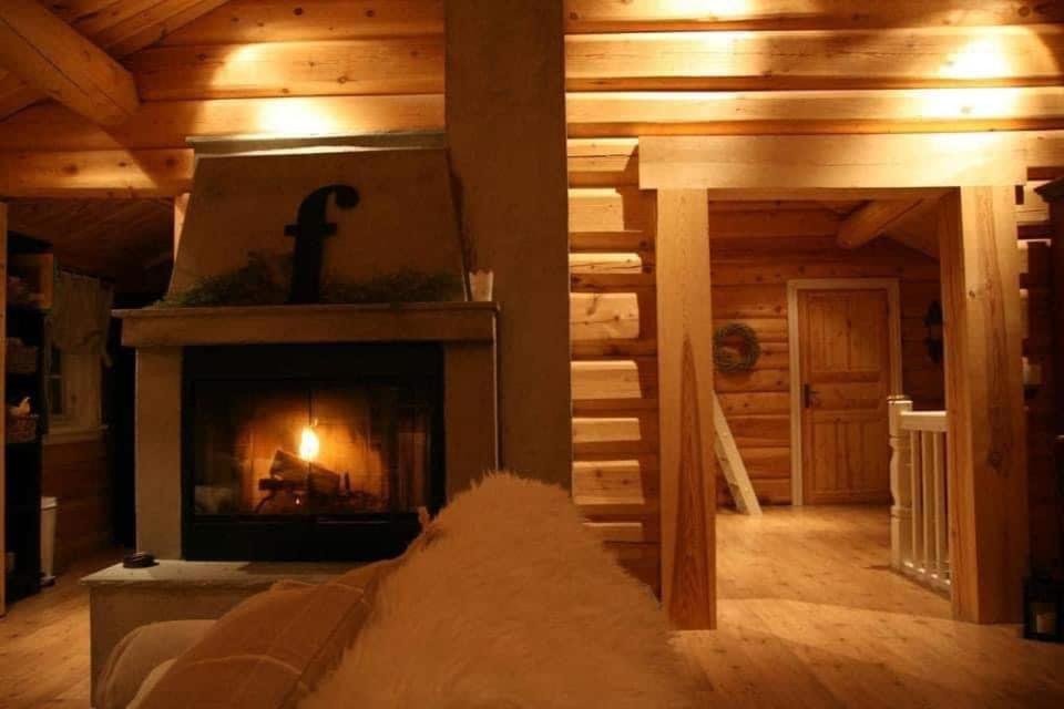 a living room with a fireplace in a log cabin at Large and beautiful cabin in Løfald