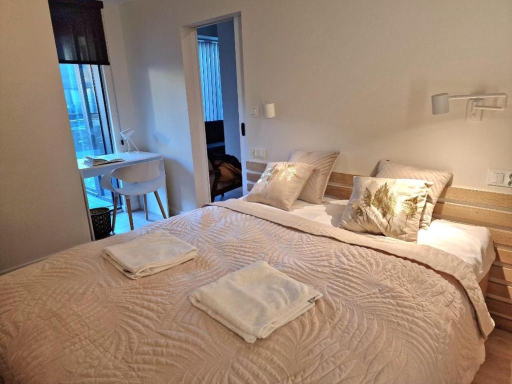 a large bed with two towels on top of it at Hanza Tower 615 in Szczecin