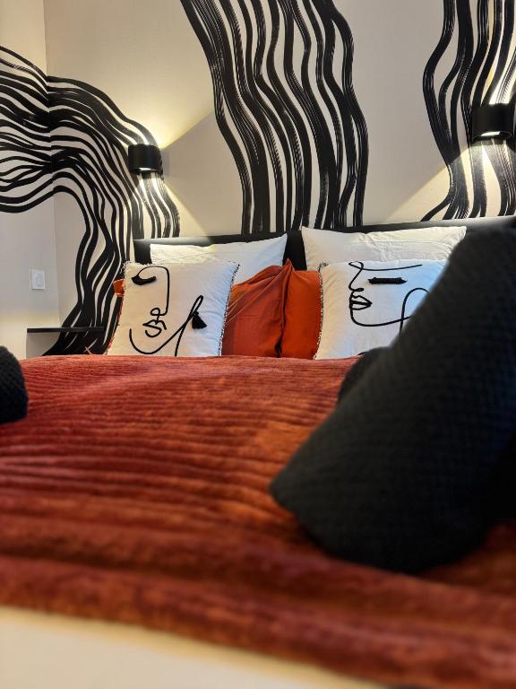 une chambre avec un grand lit avec des oreillers dans l'établissement Suite romantique - Jolies Courbes, à Broons