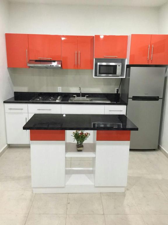 a kitchen with orange and white cabinets and a plant at Departamento "A" Fracc Cd Del Valle in Tepic