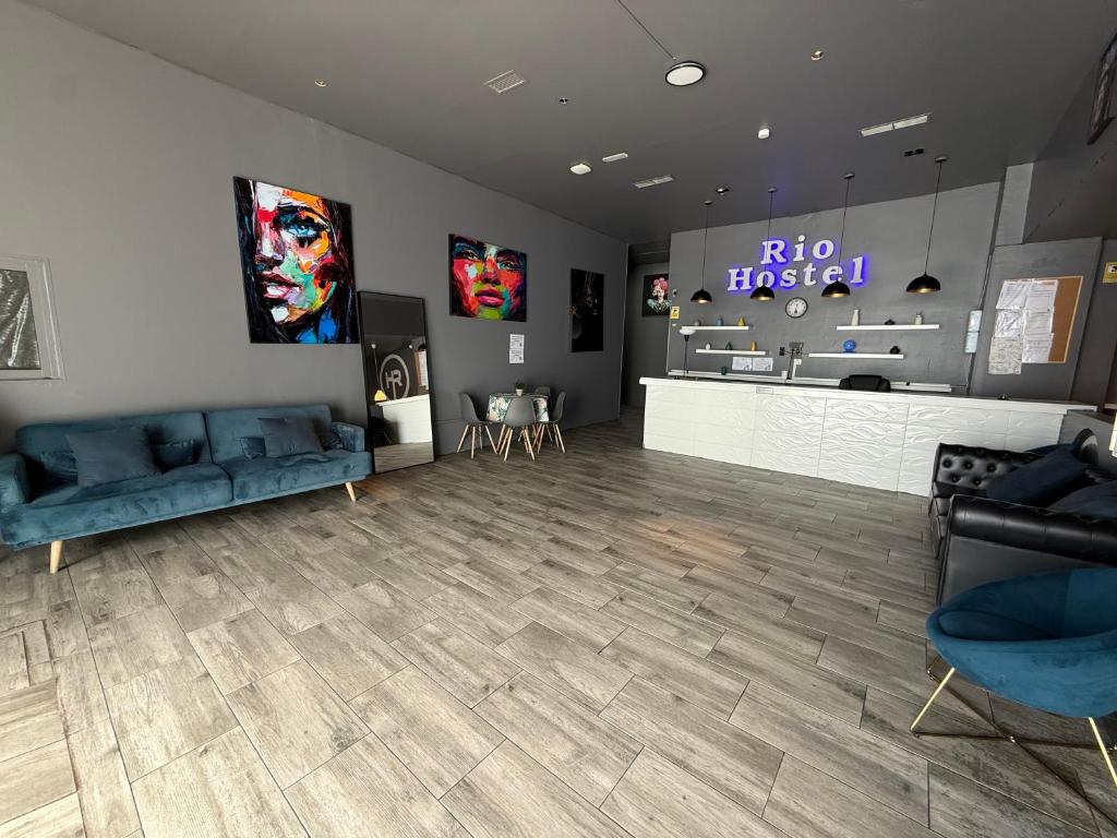 a waiting room with blue couches and a store at Rio Hostel in Madrid
