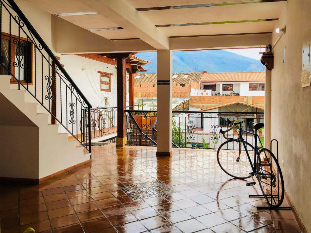 Una bicicleta estacionada en un porche con balcón en HOTEL RUTA 40 VILLA DE LEYVA, en Villa de Leyva