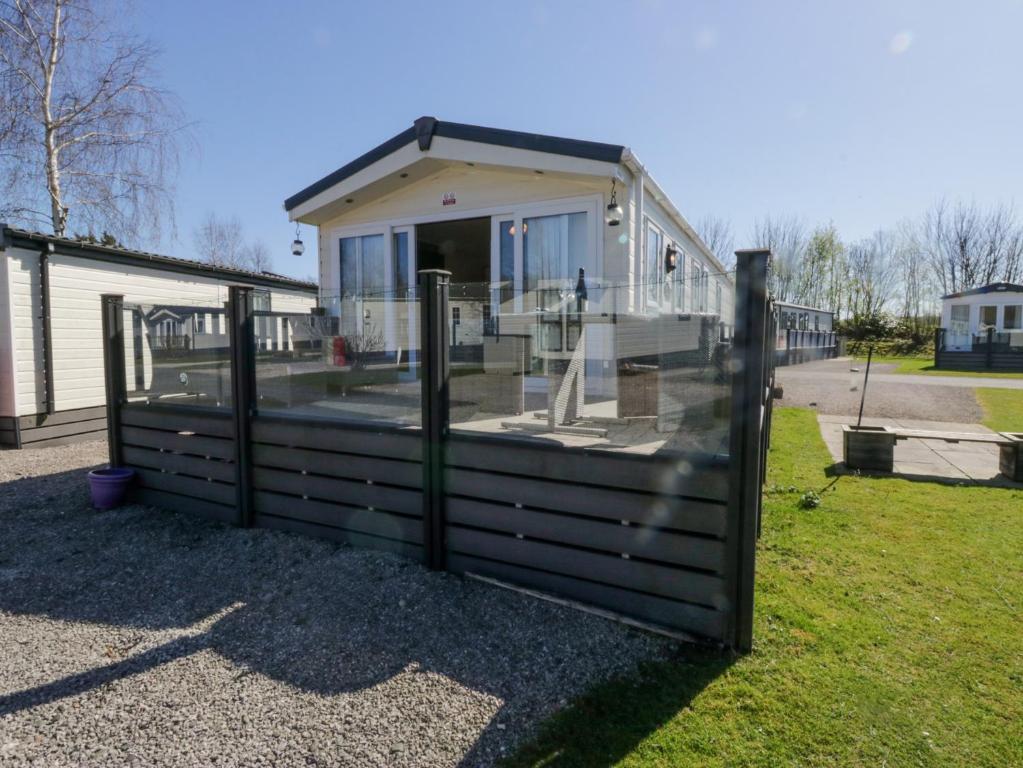 una valla de madera delante de una casa en Lakeside Haven, en Carnforth