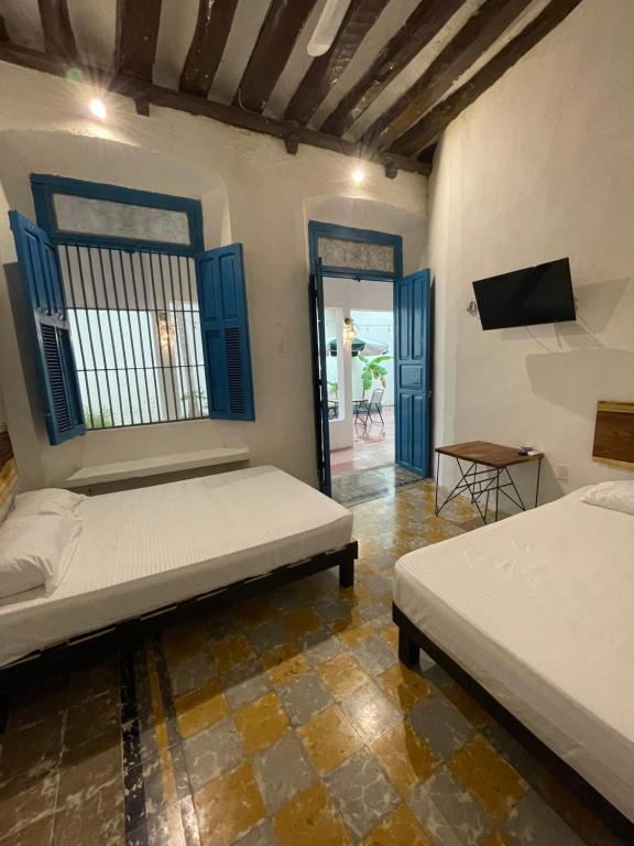 a room with two beds and a tv in it at Villa Mediterranea in Campeche