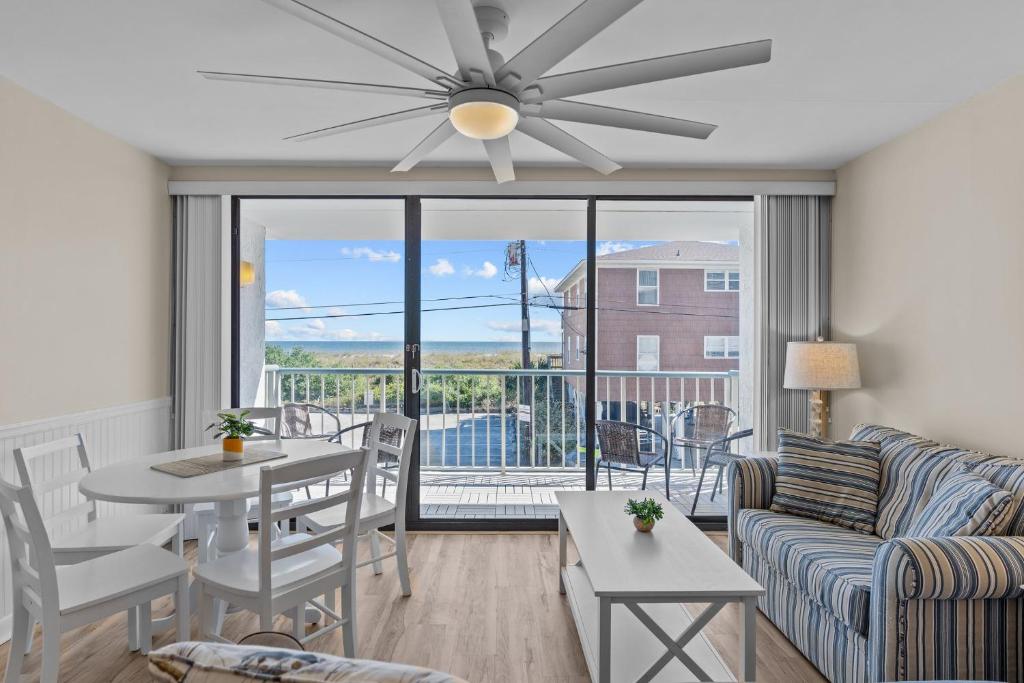 a living room with a couch and a ceiling fan at Paradise Towers #104 in Carolina Beach
