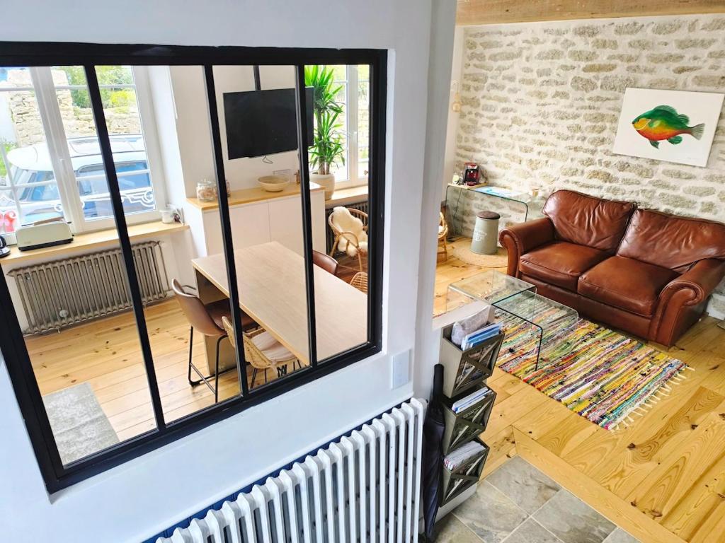 - un salon avec un miroir et un canapé dans l'établissement Au calme, maison en pierres proche de la plage, au Guilvinec